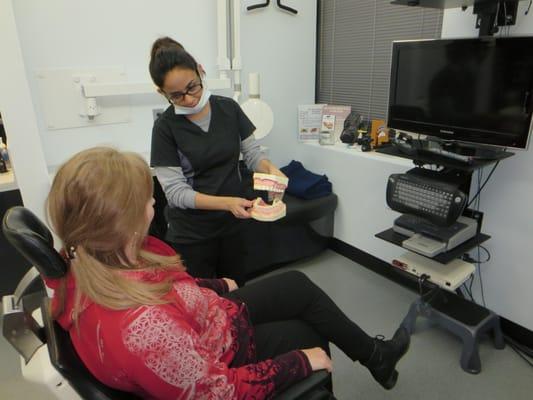 Our dental assistant "B" shows a patient the proper way to brush and floss.