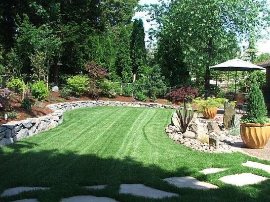 Lawn, retaining wall, stone path, and dry creek bed.