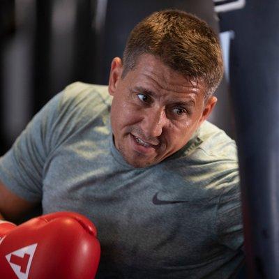 Man training with TITLE Boxing Club gloves.