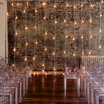 Our signature white string lights, elegantly hanging vertically behind Laura & Josh's ceremony at Gary's Loft.