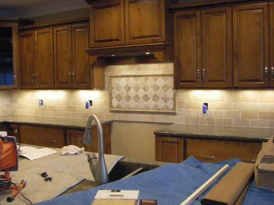 Backsplash with decorative insert over oven