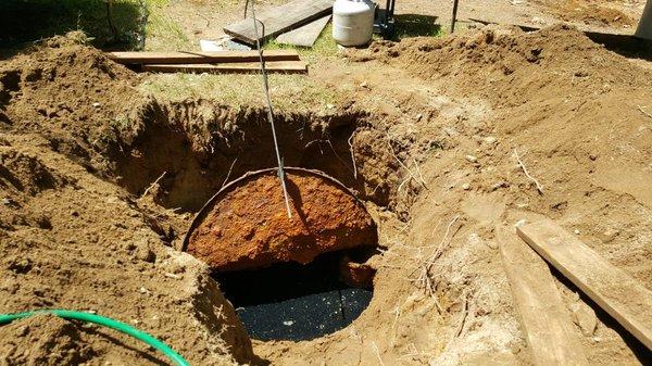 Peak Inspections uncovering a metal septic tank, no longer authorized.