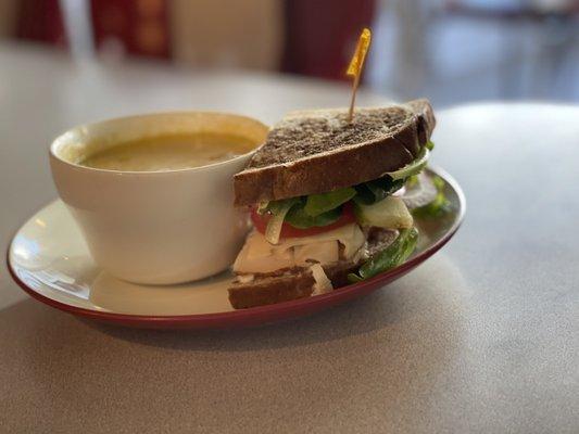 1/2 sandwich of turkey, swiss, apple, tomato, lettuce and a bowl of potato soup