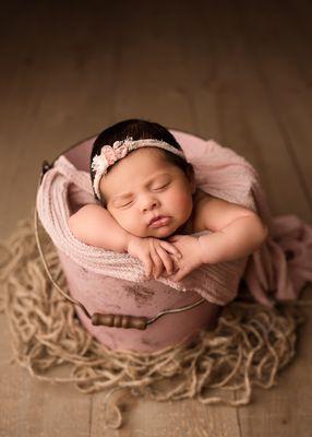 Newborn baby in pink bucket