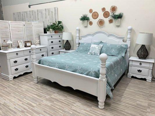 King bedroom with lightly distressed bright white paint and a new comforter.