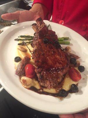 Seared pork chop,creamy polenta fontina cheese, and red wine blue berry sauce