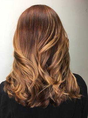 A very subtle balayage with warm reddish brown roots and golden peaks of light!