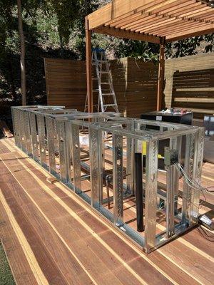 Building of an outdoor kitchen with a pergola and deck