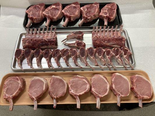 Selection of meats from the meat market: bone in ribeye steaks, lamb chops.