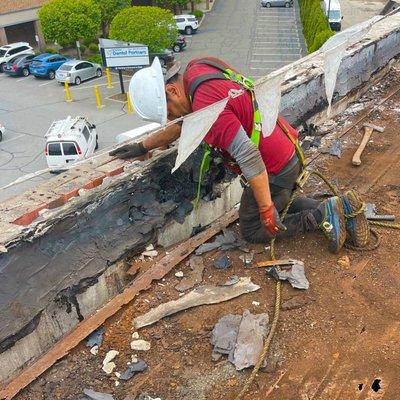 Our roofer reaching for his equipment while removing the roof layer.