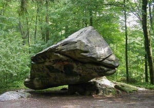 A giant triangular boulder 30 ft by 15 ft wide poised on its tip on top of another rock, a creation of the last glacial era.