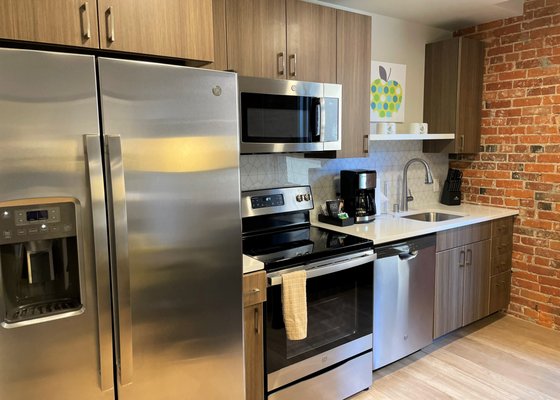 Kitchen area including stove/oven, microwave, dishwasher and full size refrigerator at Riverfront Park Travel Apartments.