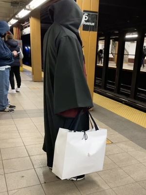 Holding the Moncler bag in the subway. Not really feeling the bag vibes as it resembles an Apple bag.