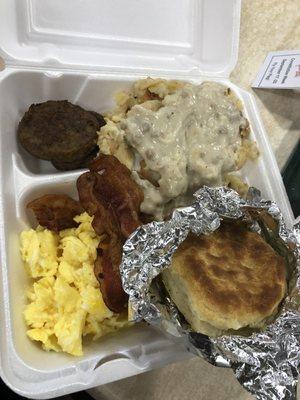 Potatoes and gravy, sausage and bacon, scrambled eggs, and a made from scratch biscuit.