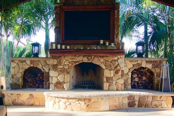 Outdoor living space. Custom rustic wooden mantel  with distressed-leather TV frame.