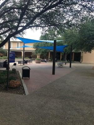 Blue canopy on the back side of the university center but in front of the library. A cool breezy spot to sit back after class.