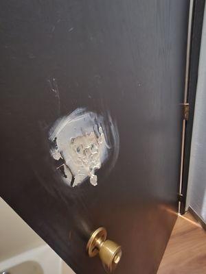 A hole in the bathroom door that was poorly patched by whatever this is