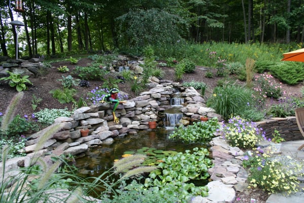 New ponds and waterfalls built into a hillside near a patio