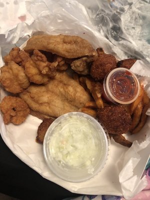 2pcs of trout, coleslaw hush puppies, French fries, fried shrimp and 2pcs of sliced bread.