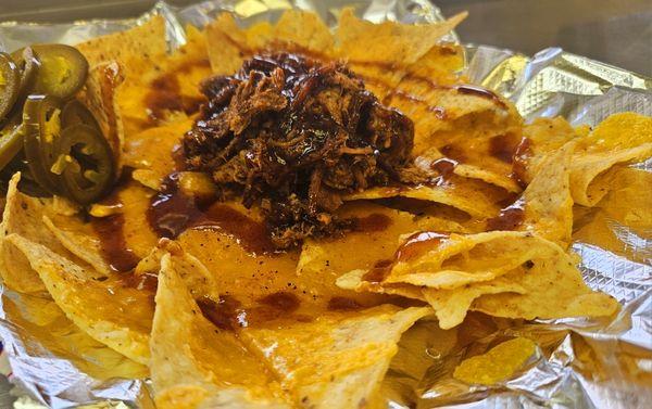 Award winning Pulled Pork Nachos with melted cheese and jalapeños