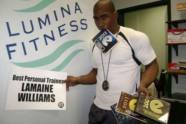 LaMaine Williams holding his awards for best personal trainer in Wilmington North Carolina