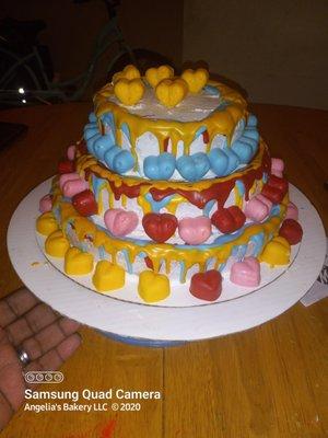 This cake is a 3 layer circle cake made with chocolate covered candies and drip. It was fun making it