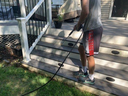 An owner in action cleaning a clients deck