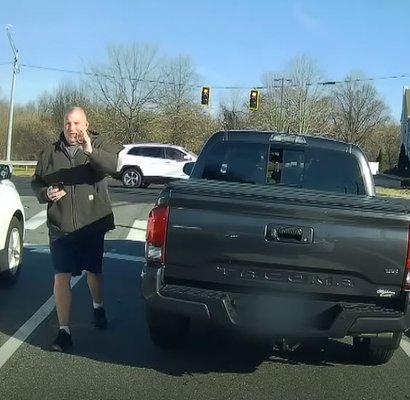 Off duty officer Allen Ganter getting out of his vehicle and flashing his badge.