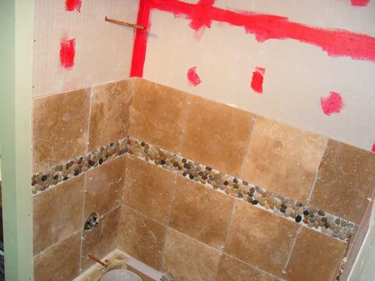 In the process of installing travertine tile in shower.