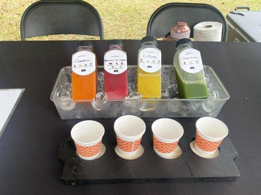 4 colorful sample bottles of organic Cold pressed juice at the Islands Farmers Market