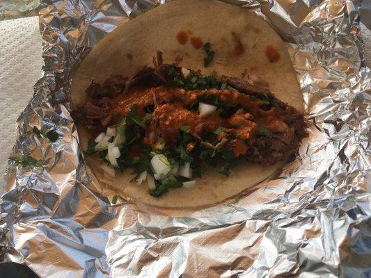 Brisket taco with spicy red sauce