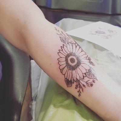 Sunflower and wildflower bouquet tattoo.