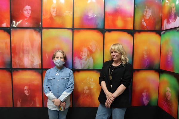 Family posing next to their auras in the Atlanta gallery showing of "Colorful You".