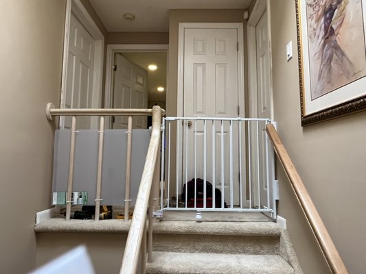 A baby gate and plastic sheet installation on a scary second floor landing