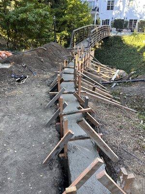 A 4 feet high by 1 foot concrete retaining wall