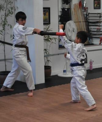 Brown Belt Jr. Warrior checks Blue Belt Jr. Warrior's blocking technique.