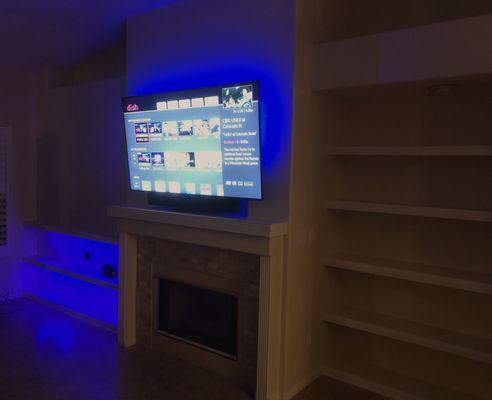 TV mounted with wire concealment. Custom shelving. LED lighting.