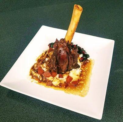 Braised lamb shank with mashed potatoes, carrots, and au jus.