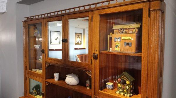 Antique furniture, with wall portraits reflected in the mirrors