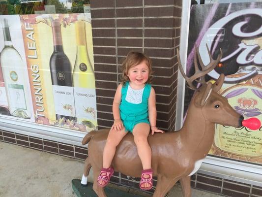 My daughter sitting on the famous deer of Lizz's Wine and Spirits.