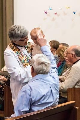 Congregation member blesses a child on the occasion of her baptism.