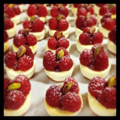 Mini New York Cheesecake with raspberry jam, fresh raspberries, and toasted pistachio.