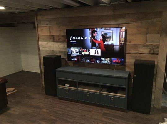 Trimmed barn wood feature wall, laminate floors, and white exposed ceilings.