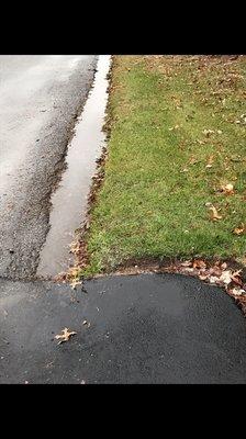 Water flowing from underneath our driveway to our neighbors driveway and lawn.