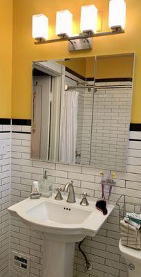 Chicago bungalow bathroom: New pedestal sink, 2 x 8 subway tiles with black borders and inset medicine cabinet for crucial storage