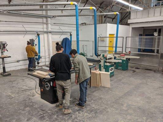 The owner Omar is helping someone get more comfortable with the table saw