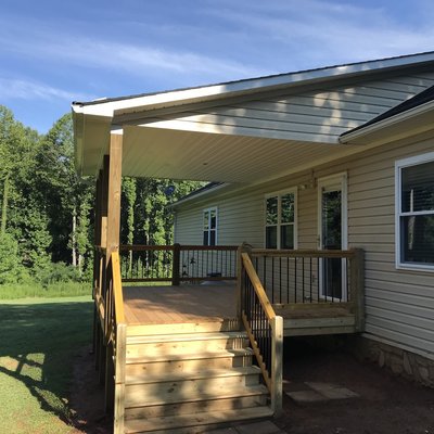 New Deck Build  (Covered Porch Construction) Pressure Treated Lumber, Vinyl Siding and Soffit Installed.