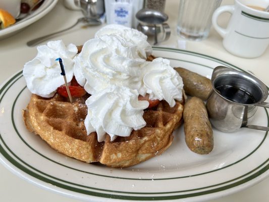 Waffle with strawberries, whipped cream and chicken sausage