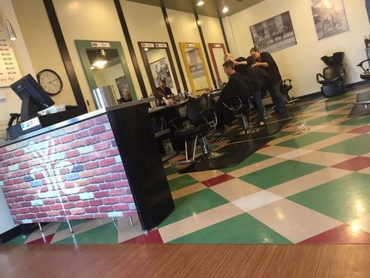 A couple of dudes getting their haircut while I wait for my turn.