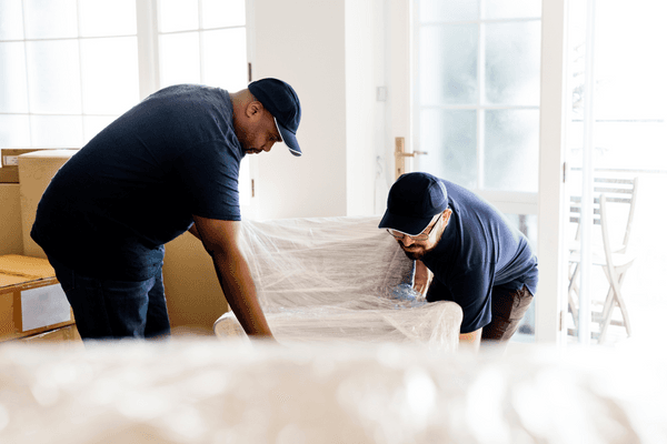 Movers placing chair into homeowners living room.